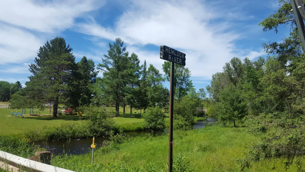 The old sign for the Hemlock River as you cross into Amasa Michigan. City park on the right on old HWY 141 south of town.